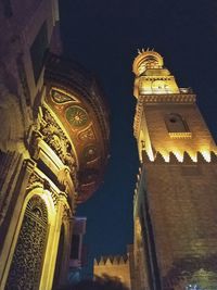 Low angle view of illuminated building against sky at night