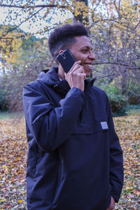 Man talking on phone while standing in forest