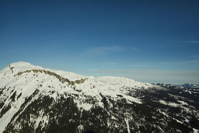 Scenic view of snowcapped mountains against blue sky