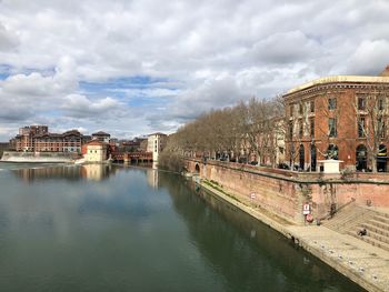 Panoramic shot of river by town against sky