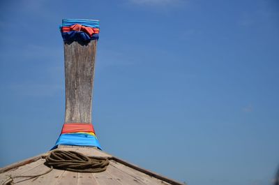 Low angle view of flags on wooden post against sky