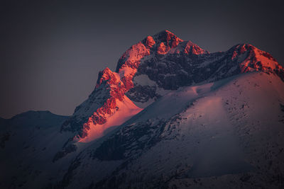 Scenic view of snowcapped mountains against sky at sunset