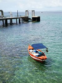 Boat moored in sea against sky