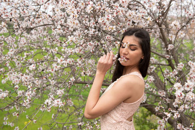 Young woman with cherry blossoms in spring
