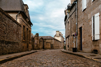 Old cobblestoned street with stone medieval houses in the town centre of dinan, french brittany