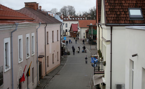 People walking on street amidst buildings in city