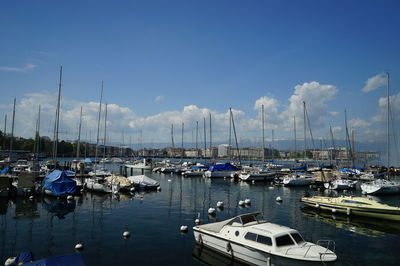 Sailboats moored on lake against sky