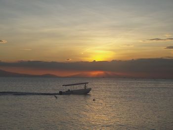 Boat sailing in sea at sunset