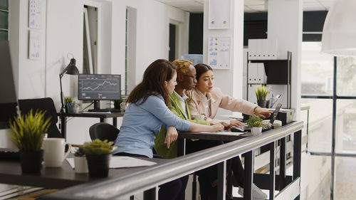 Female friends using digital tablet while sitting in cafe