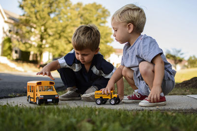 Brothers playing with toys in backyard