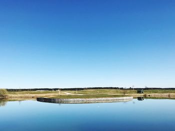 Scenic view of lake against clear blue sky