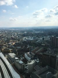 Aerial view of city against cloudy sky