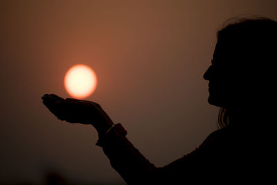 Cropped hand of woman holding illuminated string lights