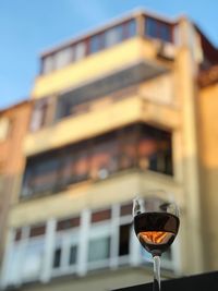 Low angle view of wine glass against building