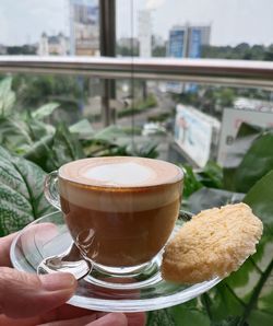 Cropped hand holding coffee on table