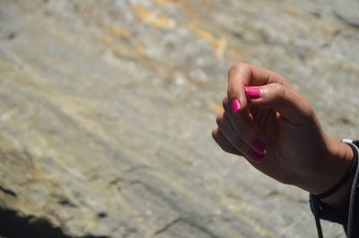 Close-up of woman hand holding water at beach