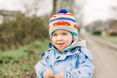 Girl in winter clothing looking away while standing outdoors