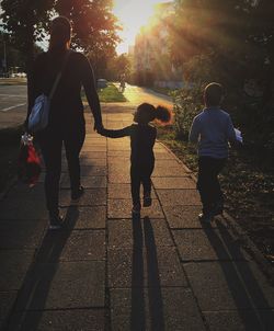Full length of father and boy running at sunset