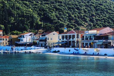 Boats moored by buildings on a small beach in the greek island of kefalonia