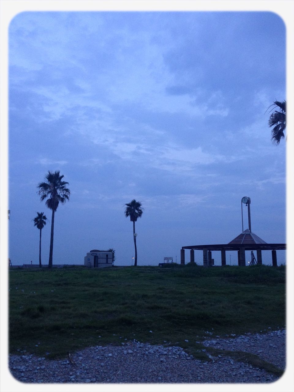 built structure, tree, sky, transfer print, architecture, palm tree, auto post production filter, building exterior, grass, cloud - sky, tranquility, nature, tranquil scene, growth, cloud, beauty in nature, scenics, outdoors, park - man made space, field