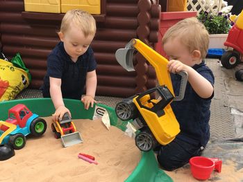 Brothers playing with toys at yard