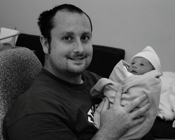 Portrait of father holding baby