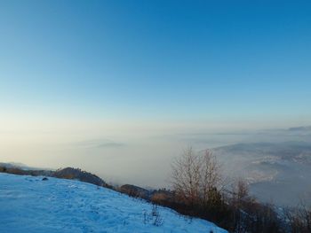 Scenic view of snow covered landscape against clear blue sky