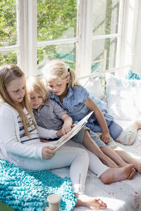 Three girls reading book