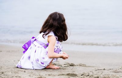 Side view of girl playing on beach