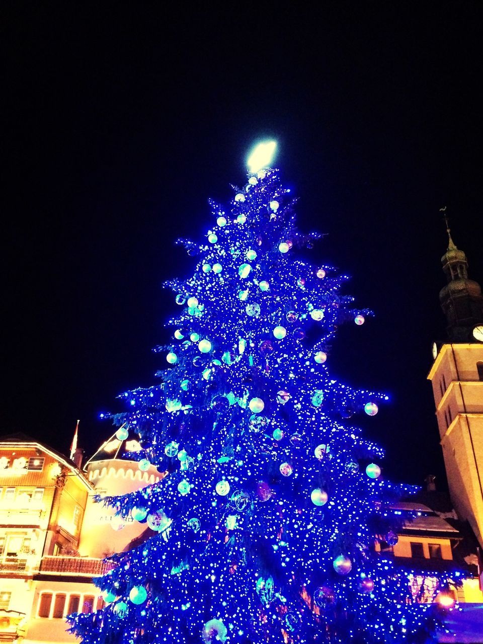 illuminated, night, building exterior, architecture, built structure, low angle view, celebration, city, lighting equipment, clear sky, sky, decoration, multi colored, outdoors, christmas lights, christmas, christmas tree, building, no people, christmas decoration