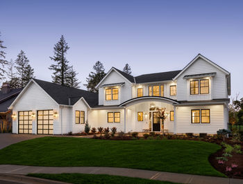 Beautiful modern farmhouse style luxury home exterior at twilight