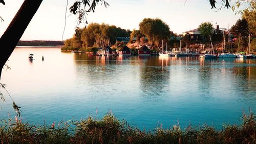 Boats moored in lake during sunset