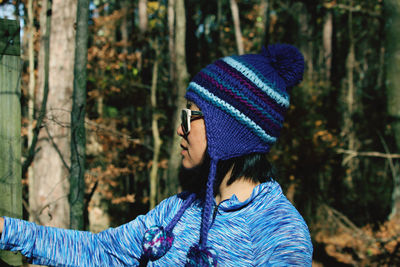 Woman wearing knit hat in forest