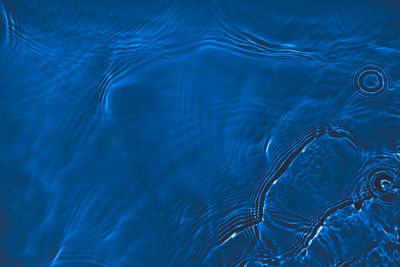 Transparent dark blue colored clear calm water surface texture