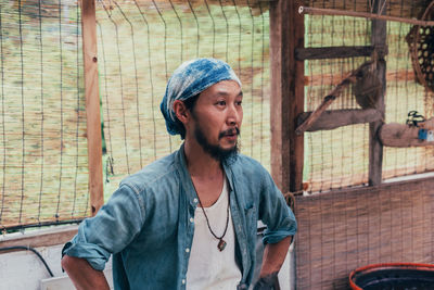 Man looking away while standing in shed