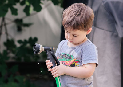 Curious toddler is playing with objects in the backyard.