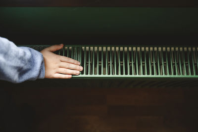 Hand of boy touching radiator at home