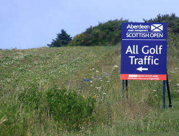 Close-up of sign board on field