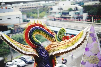 Close-up of multi colored umbrellas on city buildings