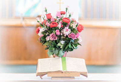 Close-up of books and bouquet on table