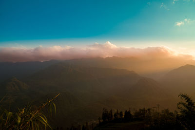 Scenic view of silhouette mountains against sky at sunset
