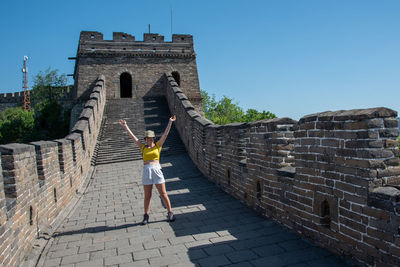 Rear view of woman on the wall of historical building