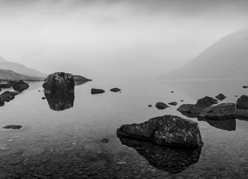 Rocks by sea against sky