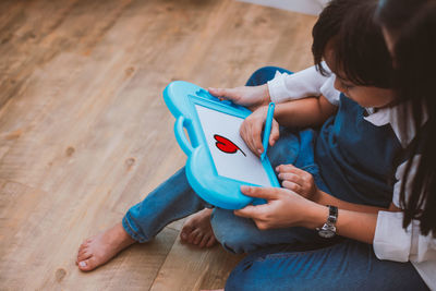 High angle view of woman sitting on hardwood floor