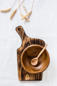 Empty wooden bowl and spoon on cutting board and ears on cloth. top and vertical view. 