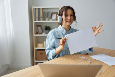 Portrait of young woman reading book at home