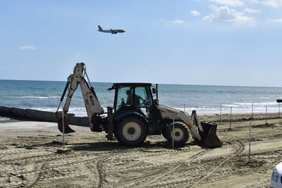 View of airplane and bulldozer on beach