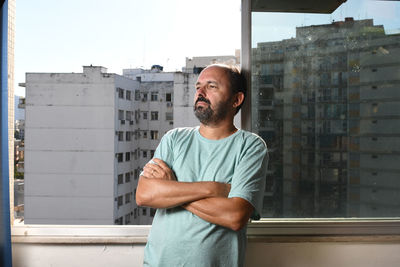 Man leaning by the window with thoughtful expression