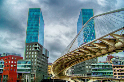 Low angle view of modern building against cloudy sky