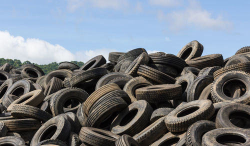 Stacked tires against sky